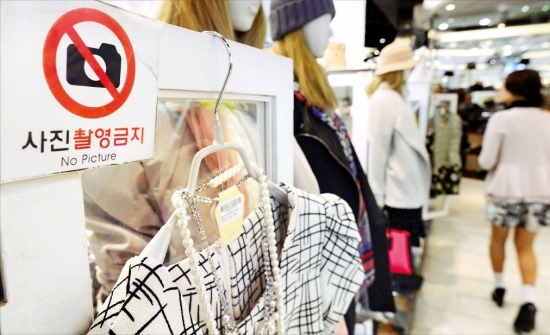 < “사진 찍지마세요” /> 서울 동대문에 있는 한 쇼핑몰 매장에 사진 촬영을 금지하는 팻말이 붙어 있다. 동대문 쇼핑몰은 몰래 제품 사진을 찍어가는 중국인 디자인 파파라치들로 몸살을 앓고 있다. 김병언 기자 misaeon@hankyung.com